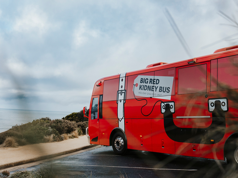 The Big Red Kidney bus parked by the beach