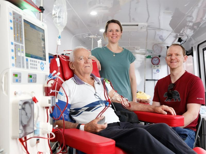 Three people on the big red kidney bus