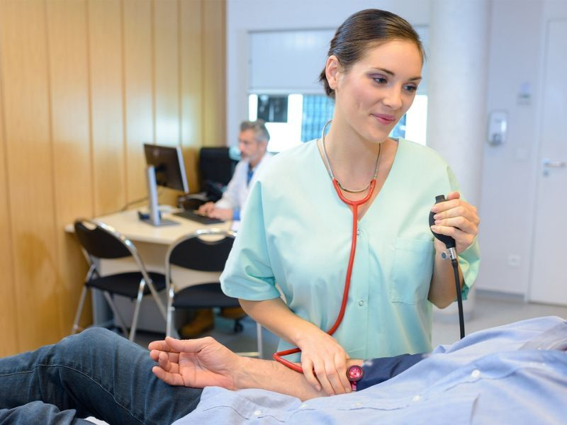 A female health professional checking a patient's blood pressure