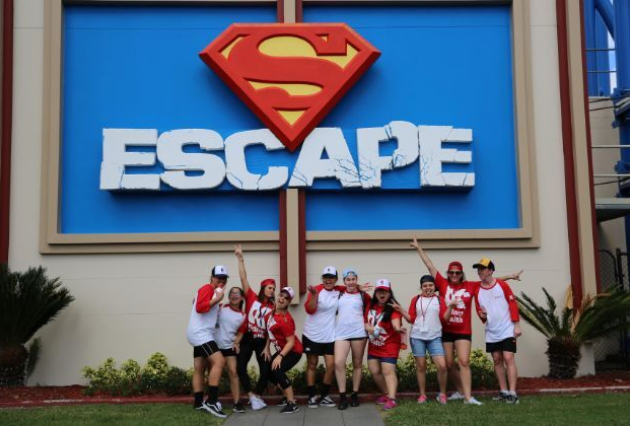 A group of kids pose in front of escapers sign