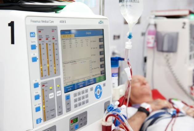 An older man lies down while on dialysis