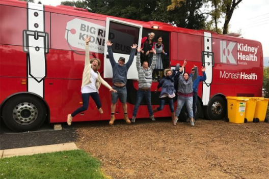 Kidney Health Big Red Bus employees pose in front of the bus